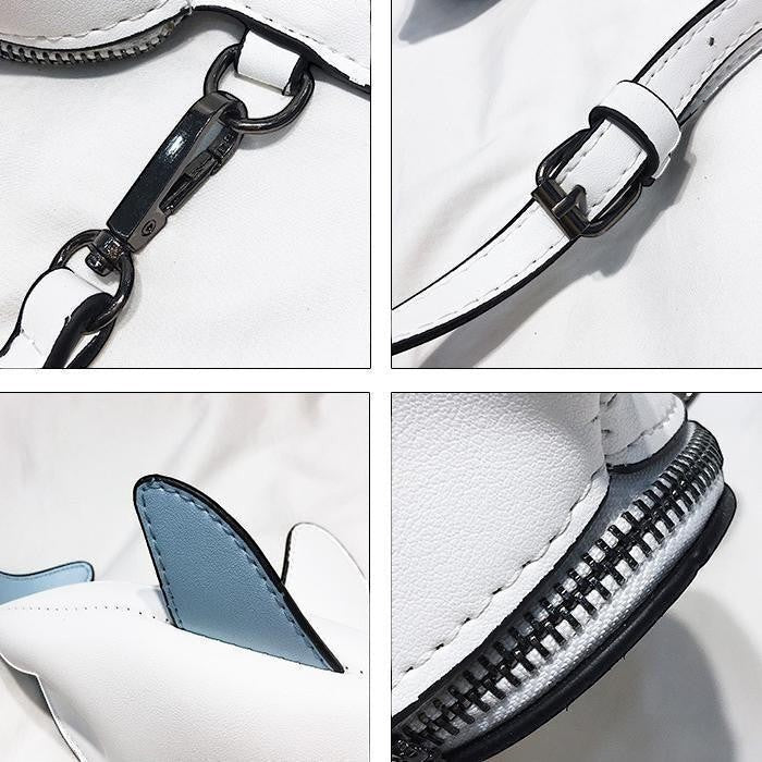 Pordein Baby Shark Mini Bag, a white PU leather handbag with blue fins and a zip closure.