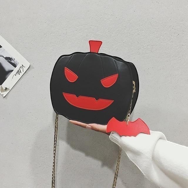 Pordein black vegan leather Halloween pumpkin handbag with red face details and bat keychain.