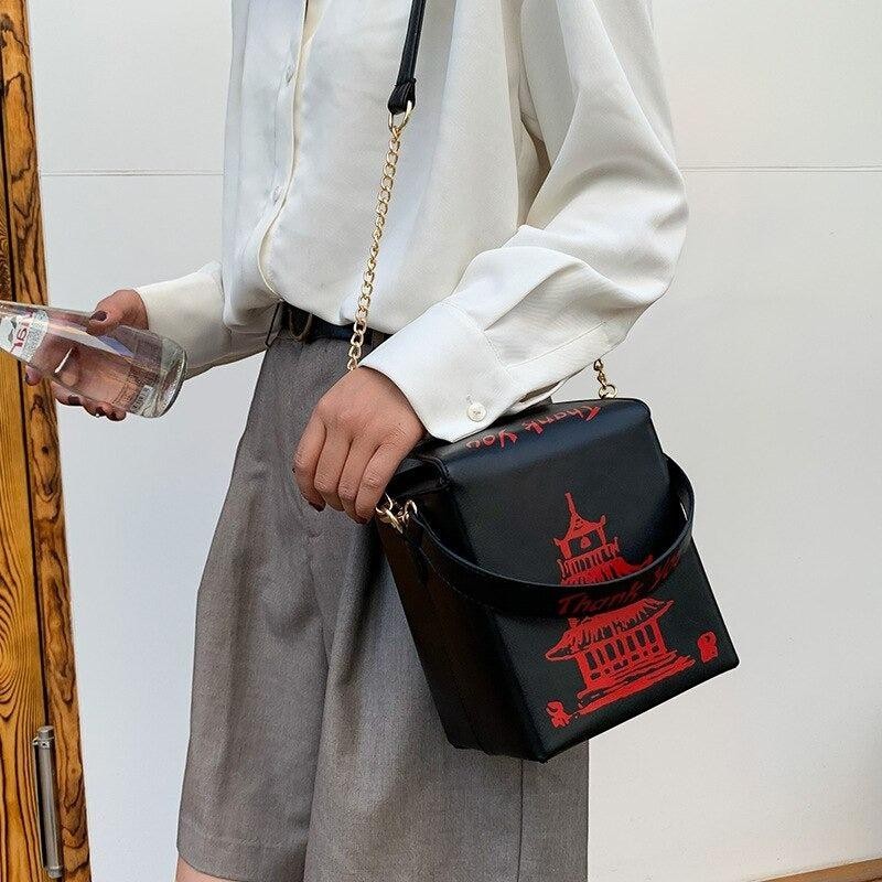 Pordein black PU leather mini bag shaped like a Chinese takeaway box with red pagoda and text detail.