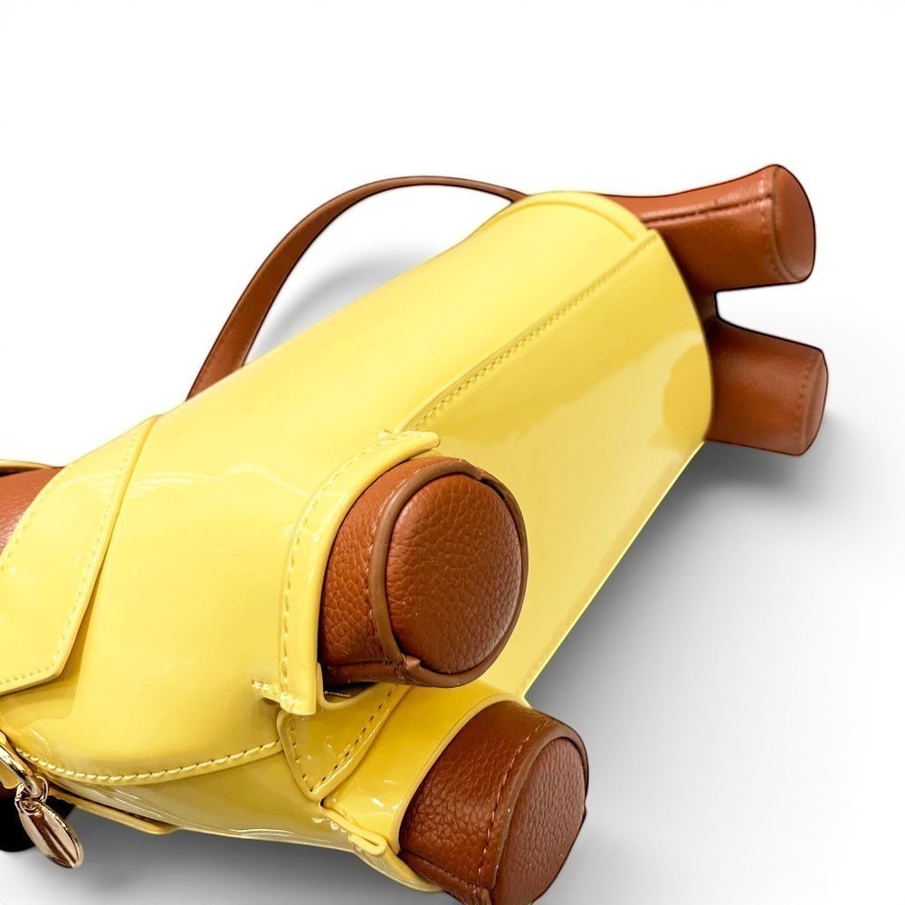 Pordein yellow patent leather dachshund shoulder bag with brown trim and details.