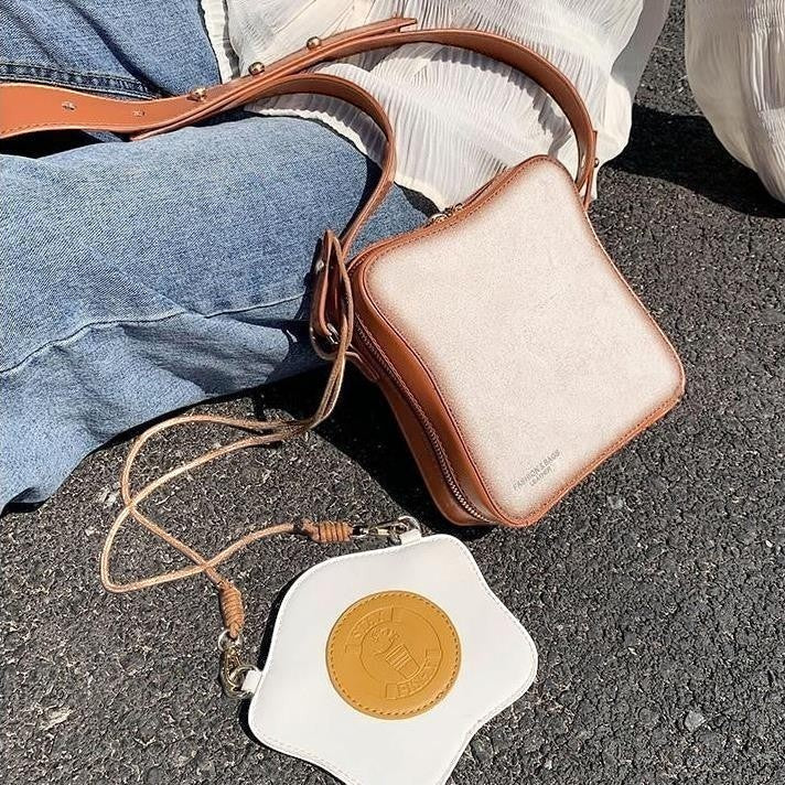 Pordein Eggs & Toast mini bag, a white toast-shaped bag with brown trim and a separate fried egg coin purse.