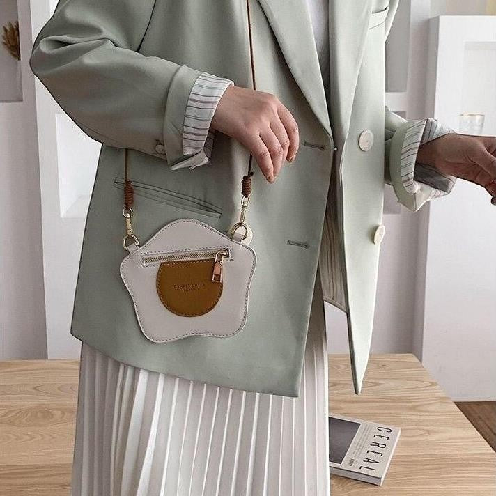Pordein Eggs & Toast mini bag, white PU leather with brown yolk detail, zipper closure, adjustable strap.