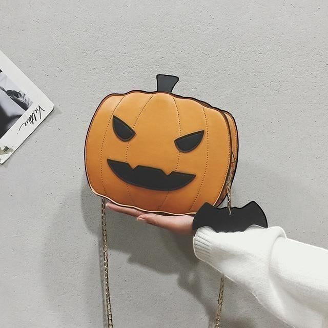 Pordein orange Halloween pumpkin bag with black face details and bat keychain. Made of PU leather.