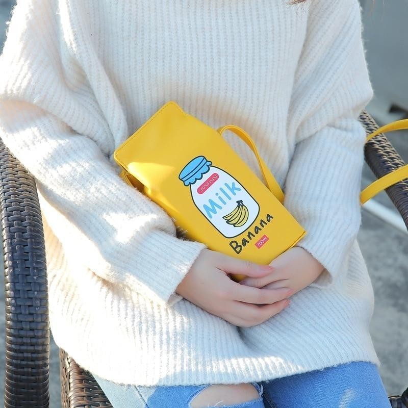 Pordein yellow PU leather mini bag shaped like a milk carton with "Milk Banana 750ml" graphic. Adjustable strap.