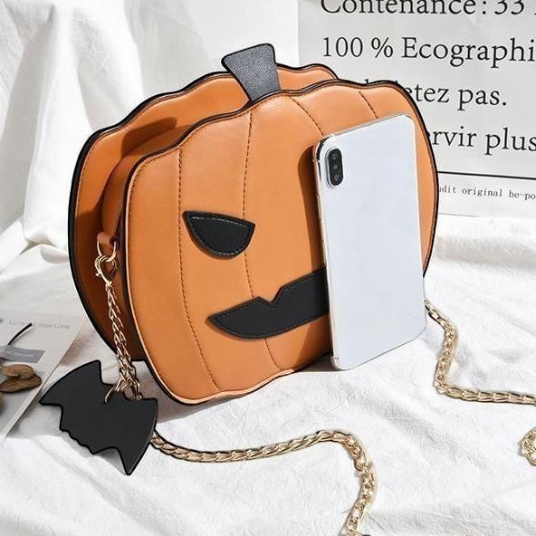 Pordein orange pumpkin handbag with black face details and bat keychain. Vegan PU leather.