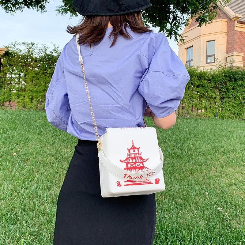 Pordein white mini bag shaped like a Chinese takeaway box with red pagoda and "Thank You" print. Made of PU leather.
