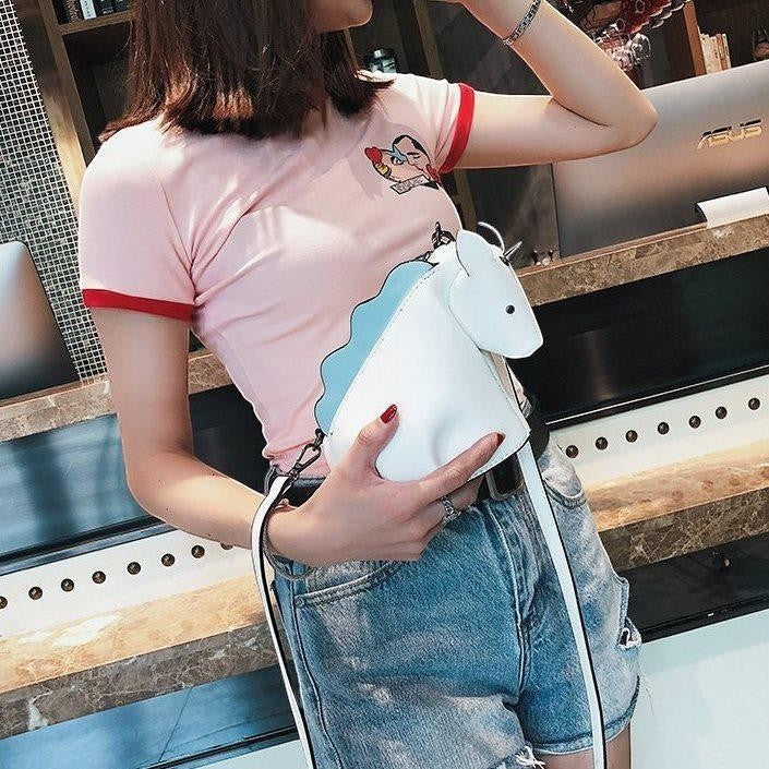 Pordein white and blue PU leather unicorn mini bag with adjustable strap, held by a woman.